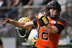 B.C. Lions quarterback Nathan Rourke  is pushed out of bounds by Edmonton Elks' Jalen Collins as he runs with the ball during the first half of CFL football game in Vancouver, on Saturday, June 11, 2022.