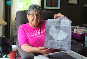 Shirley Christmas, 71, hold up a piece of a peak cap she is working on, showing the bead pattern it will have. NICOLE SULLIVAN/CAPE BRETON POST