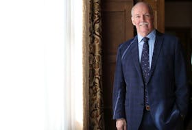 British Columbia Premier John Horgan poses for a portrait after a swearing-in ceremony at Government House in Victoria, Friday, Feb. 25, 2022.