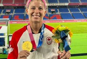 Stephanie Labbé holds the Olympic gold medal she won with the Canadian National Team. Labbé will be in Cape Breton this weekend for her champion tour soccer clinic, scheduled for the Ness Timmons Turf Field in Sydney on Sunday. TWITTER PHOTO.