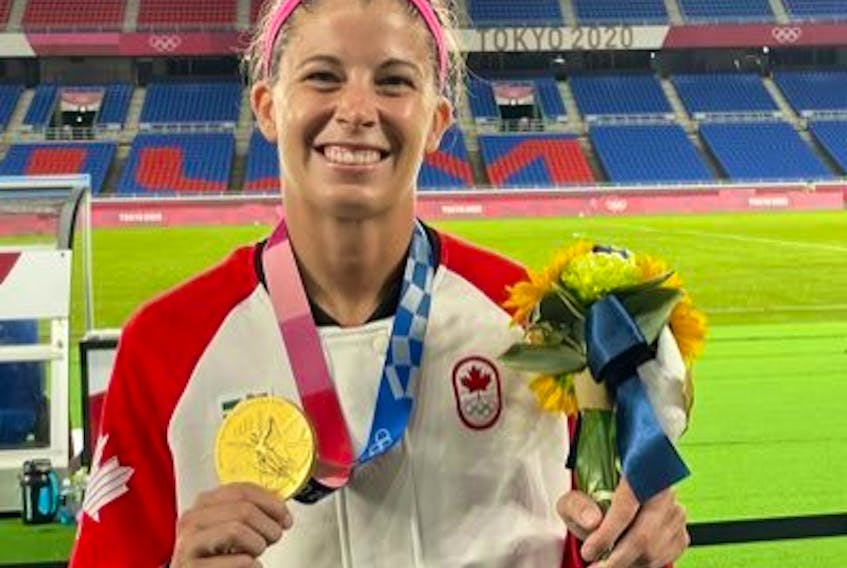 Stephanie Labbé holds the Olympic gold medal she won with the Canadian National Team. Labbé will be in Cape Breton this weekend for her champion tour soccer clinic, scheduled for the Ness Timmons Turf Field in Sydney on Sunday. TWITTER PHOTO.