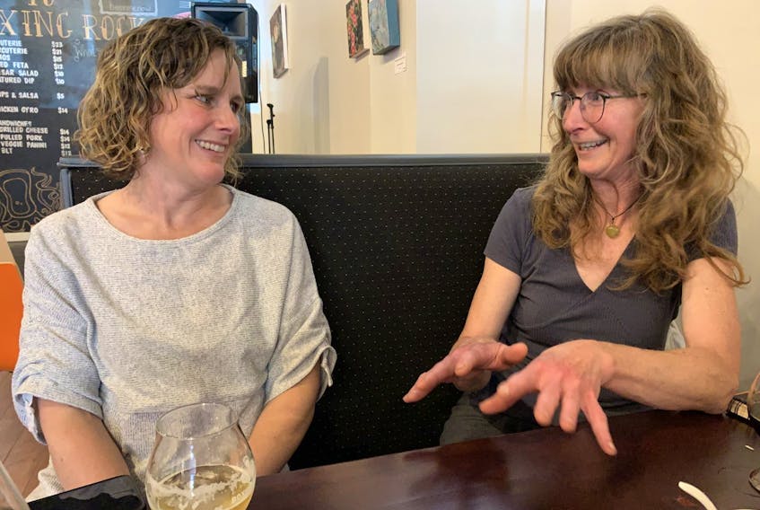 Emily Cowin (left), co-founder of the Boxing Rock Brewing Company and multi-faceted artist Kim Smerek talk art and community while sharing a brew at the company’s taproom. A solo exhibit of Smerek’s work will be on display in the taproom until August. KATHY JOHNSON