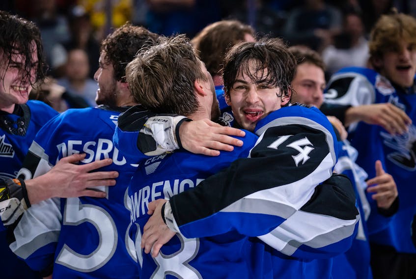 Beaver Bank’s Ryan Francis, right, hugs teammate Josh Lawrence after the Saint John Sea Dogs won the Memorial Cup on home ice on June 29 by beating the Hamilton Bulldogs.