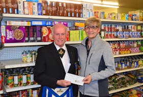 Van MacLeod presents a cheque for $5,800 from the Masons of Pictou County to the Pictou County Food Bank in New Glasgow. Accepting the cheque is Lia LeClair.