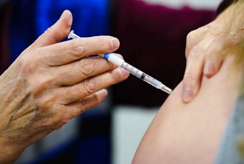 A health worker administers a dose of a COVID-19 vaccine during a vaccination clinic at the Keystone First Wellness Center in Chester, Pa., on Dec. 15, 2021. 