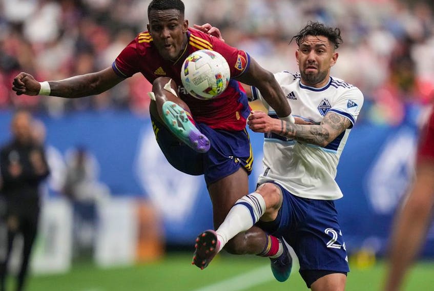 Real Salt Lake's Sergio Cordova, left, and Vancouver Whitecaps' Erik Godoy vie for the ball during the first half of an MLS soccer game in Vancouver, on Saturday, June 4, 2022.