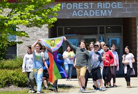 Students, including the Gay Straight Alliance Club, at Forest Ridge Academy proudly carry the Pride flag out to the school’s flag pole for a flag-raising ceremony on June 1. KATHY JOHNSON