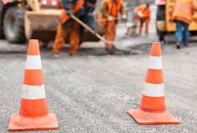 road workers repairing the road with shovels, dub asphalt with shovels at the back, the cones in the foreground  Work on a new roundabout is expected to cause traffic delays in the MacKinnon Drive area.