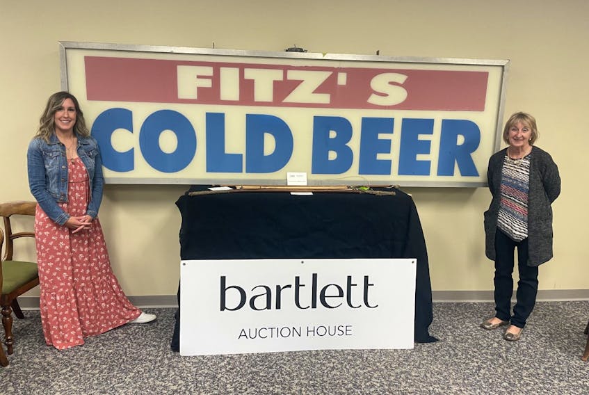 Angie Fitzpatrick (left) and her mother, Christine Fitzpatrick, visited Bartlett Auction House at Atlantic Place Sunday, June 5, where the iconic sign “Fitz’s Cold Beer” was being auctioned, with proceeds going to the Dr. H. Bliss Murphy Cancer Care Foundation. 