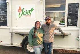 Sarah MacIsaac, left, and her partner Laughlin MacDonnell stand outside their food truck, the Joint Mobile Grill, in Inverness. The couple says a new Municipality of the County of Inverness bylaw is taking a bite out of their business. Contributed