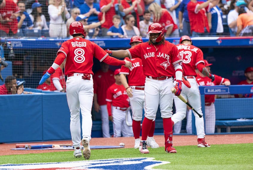 Toronto Blue Jays second baseman Cavan Biggio scores a run and celebrates with Toronto Blue Jays first baseman Vladimir Guerrero Jr. against the Tampa Bay Rays during the third inning at Rogers Centre on July 1, 2022.