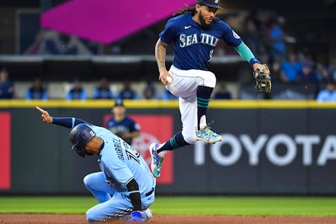 J.P. Crawford of the Seattle Mariners leaps after getting a force out on Lourdes Gurriel Jr. of the Toronto Blue Jays during the fifth inning at T-Mobile Park on Saturday night. 
