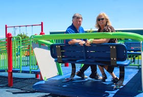 Barrie Fiolek, left, and Janine Fiolek sit on the wheelchair accessible gliding swing recently added to the memorial park in their daughter, Marcia Fiolek's name. The couple are a part of the committee who oversee the maintenance of the playground in Dominion. NICOLE SULLIVAN / CAPE BRETON POST