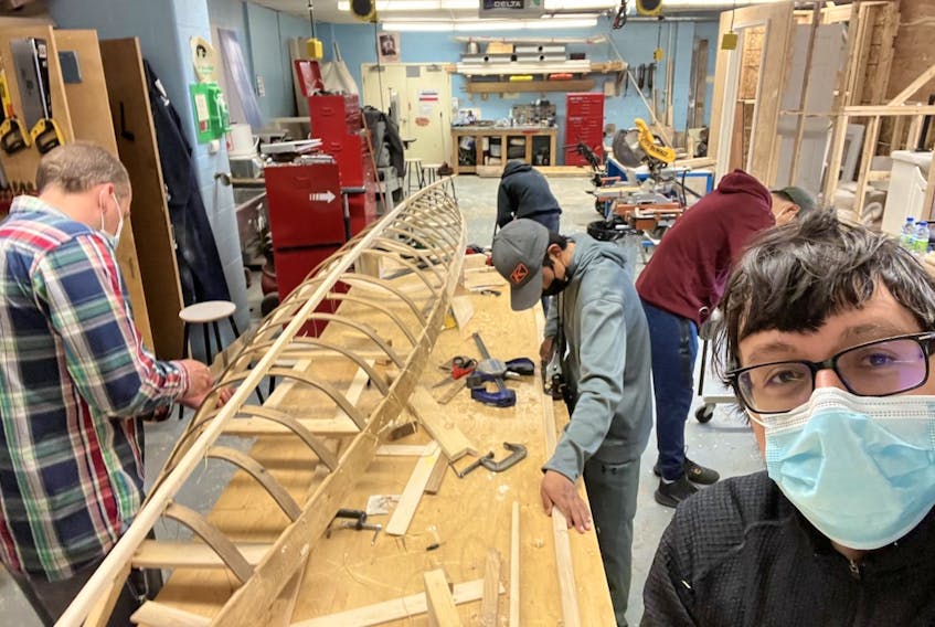 Noah Nochasak (foreground) recently oversaw the building of a traditional Inuit Kajak (kayak) by Grade 8 students in Nain.