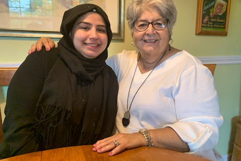 Aya Latif sits with friend Kathy Calder. The 17-year-old Latif recently graduated from Amherst Regional High School and is going to study to be a continuing care assistant (CCA) at NSCC Amherst in September. She has come a long way since her arrival in 2015 as part of the Amherst Rotary Club’s Syrian Refugee Project. Darrell Cole