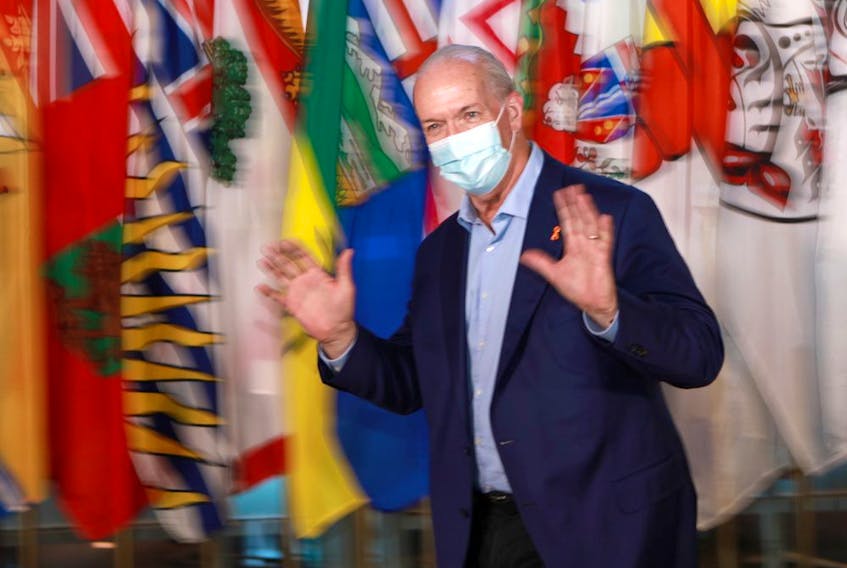 Premier John Horgan gestures during a break from the summer meeting of the Canada's premiers in Victoria on Monday.