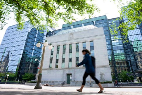 A woman walks past the Bank of Canada headquarters, Wednesday, June 1, 2022 in Ottawa.  