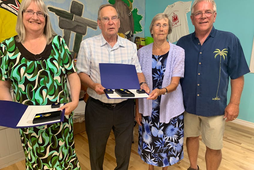 Lisa Emery and Wayne and Evelyn Bishop accept their 2021 and 2022 Community Paul Harris Fellowship awards from Amherst Rotary Club president Rick VanSnick. Darrell Cole