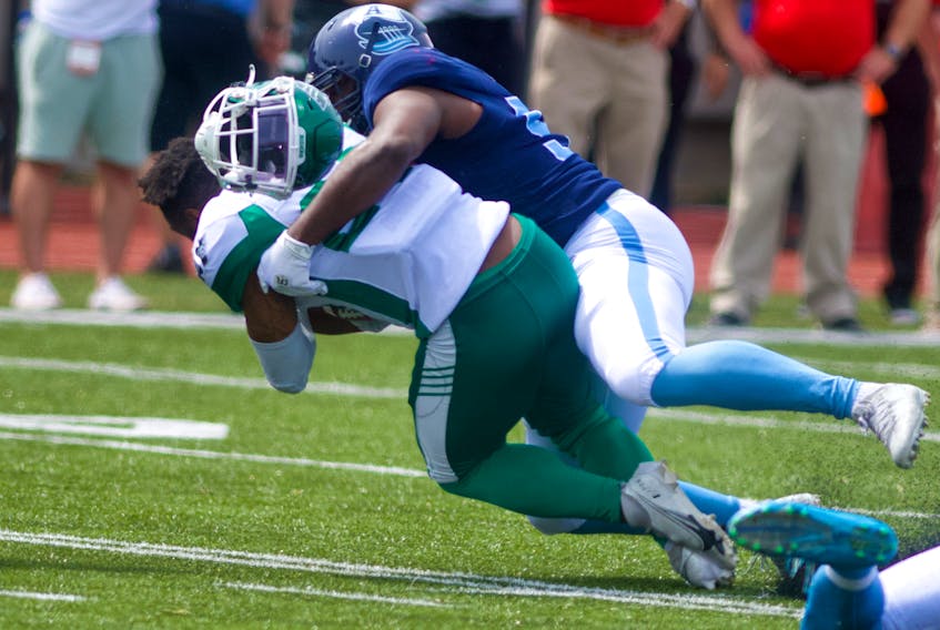 Saskatchewan Roughriders running back Jamal Morrow has his helmet knocked off as he’s tackled by Toronto Argonauts defensive lineman Ja’Gared Davis during the first half of CFL action at Raymond Field in Wolfville on Saturday, July 16, 2022. Ryan Taplin - The Chronicle Herald