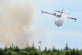 A provincial forestry waterbomber drops a load of water over a forest fire at the end of Scott’s Road South in Upper Gullies, Conception Bay South, on Sunday afternoon, July 17,  while assisting crews at ground level. Despite tense moments at times, the fire appeared to be contained and under control shortly after 4 p.m. on Sunday afternoon. 
Joe Gibbons/The Telegram