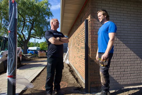 Mike Holmes and son Michael on location of Holmes Family Rescue, where spray cork was used to enhance and restore the home's brickwork. 