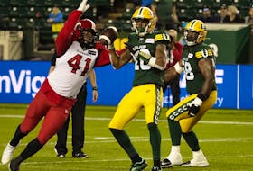 Edmonton Elks' quarterback Kai Locksley (10) is hit by Calgary Stampeders' Mike Rose (41) for a penalty during second half CFL action at Commonwealth Stadium in Edmonton, on Thursday, July 7, 2022. 