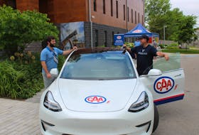 Brendan Piper, left, of Next Ride, discusses the benefits of the electric vehicle with Chad Bennett who took his first test drive Friday. CAPE BRETON POST PHOTO