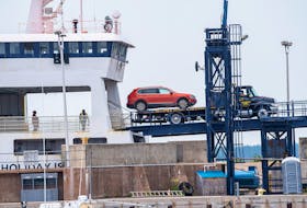 A tow truck unloads a vehicle from the MV Holiday Island at the ferry terminal in Wood Islands on July 24. Passengers had to leave their vehicles behind July 22 after a fire forced the evacuation of the ferry.  Brian McInnis • Special to The Guardian