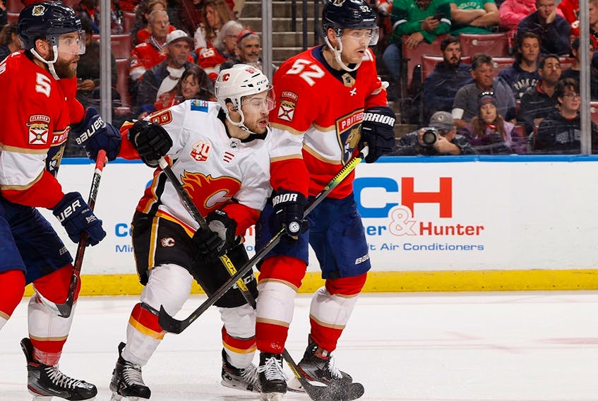Then-Florida Panthers defenceman MacKenzie Weegar (right) defends against Calgary Flames forward Andrew Mangiapane at the BB&amp;T Center in Sunrise, Fla., on March 1, 2020.