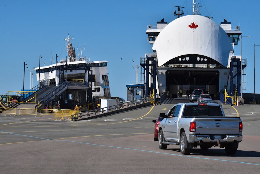 The MV Holiday Island, left, rests crookedly in its berth next to the MV Confederation which will take over providing ferry service to Nova Scotia as of July 28. - Alison Jenkins • The Guardian
