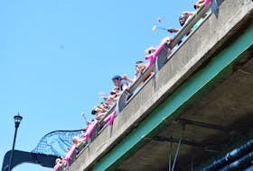 Family and friends of those who have battled or died with cancer gathered on the George Street bridge for the pink carnation ceremony.