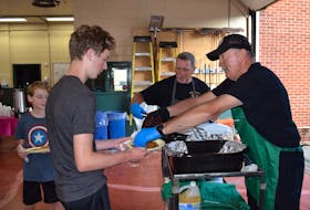 Stellarton fire chief Mike O’Sullivan, right, and firefighter Mark Fortune serve pancakes and sausages during the department’s popular pancake breakfast during Stellarton Homecoming. Ray Burns – The News