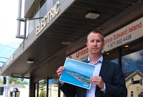 Maritime Electric CEO Jason Roberts holds up a copy of the 2022 sustainability report, a new report the company will release annually to inform customers about the changes being made to move towards greener energy. Rafe Wright •The Guardian