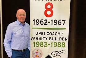 Vince Mulligan poses with a banner recognizing his contributions to the St. Dunstan’s and UPEI men’s hockey program. Friends of UPEI Hockey hosted the ceremony during its annual Hot Stove Night on the UPEI campus recently. Contributed
