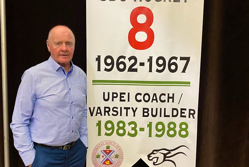 Vince Mulligan poses with a banner recognizing his contributions to the St. Dunstan’s and UPEI men’s hockey program. Friends of UPEI Hockey hosted the ceremony during its annual Hot Stove Night on the UPEI campus recently. Contributed
