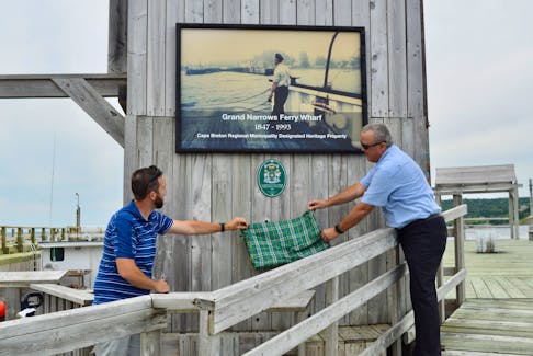 The Grand Narrows Ferry Wharf is the newest heritage property in the Cape Breton Regional Municipality. A ceremony unveiling the redeveloped facility was held Sunday when CBRM councillor Cyril MacDonald, left, and Victory County councillor Paul MacNeil pulled back a tartan cloth to reveal the official plaque. The ferry connected Grand Narrows with Iona on the other side of the Barra Strait. DAVID JALA/CAPE BRETON POST