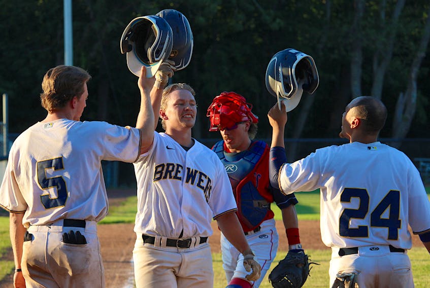 Mike Short, centre, celebrates his three-run home run with his Metro Brewers teammates July 29 in Kentville.