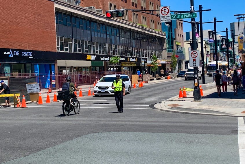 A Halifax Regional Police officer directs traffic on Spring Garden Road as part of a pilot project to limit motor vehicle traffic on the street. While the area between South Park and Queen streets is supposed to be only for buses, cyclists and pedestrians between 7 a.m. and 8 p.m. for the next year, lots of drivers were spotted ignoring the signs Monday.