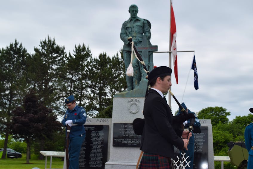 A piper passes in front of Westville's cenotaph.