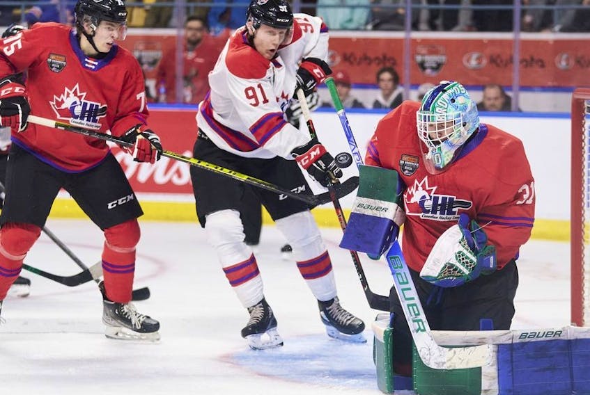Team White's Nathan Gaucher of the Quebec Remparts tries to tip the puck past Team Red goalie Reid Dyck of the Swift Current Broncos during the 2022 Kubota CHL/NHL Top Prospects game in Kitchener, Ontario on Wednesday, March 23, 2022.
 