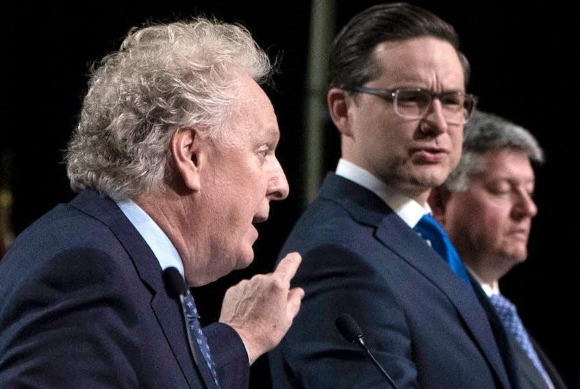 Jean Charest, left, and Pierre Poilievre, middle, spar during a Conservative leadership candidates debate in Ottawa, May 5, 2022.