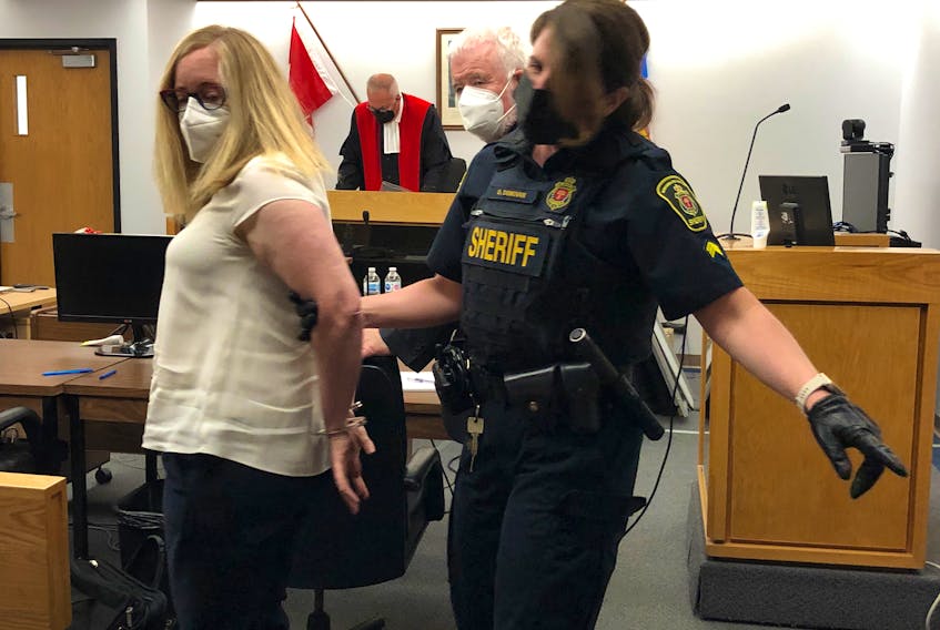 A sherrif's officer places handcuffs on Joan McCarthy's wrists before escorting her from a St. John's courtroom Wednesday afternoon to begin a federal jail sentence. McCarthy, a former financial adviser, pleaded guilty to stealing more than $700,000 from clients over a 13-year period. 