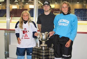 Nine-year-old Mila Betts, left, and her 14-year-old brother Nate get their photo taken with Memorial Cup champion Brady Burns Aug. 1 at the Andrew H. McCain Arena in Wolfville. The Betts siblings and Burns are all from Port Williams.