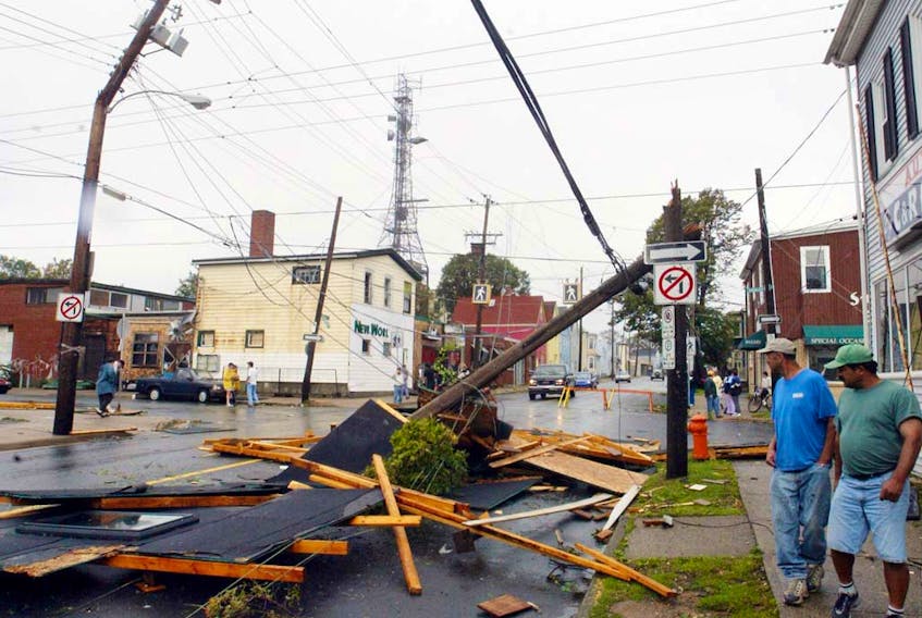Sept.29, 2003--Passersby look at the debris on Agricola Street after Hurricane Juan uprooted trees and downed power lines  throughout the region early monday morning.  Passersby look at the debris on Agricola Street in Halifax after hurricane Juan uprooted trees and downed power lines throughout the region on the morning of Monday, Sept. 29, 2003. SaltWire Network file photo