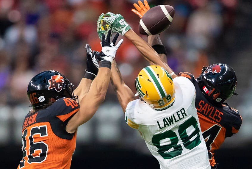 Edmonton Elks slotback Kenny Lawler (89) fails to make the reception as B.C. Lions Ben Hladik (46) and Marcus Sayles (14) defend against him in Vancouver on Aug. 6, 2022.