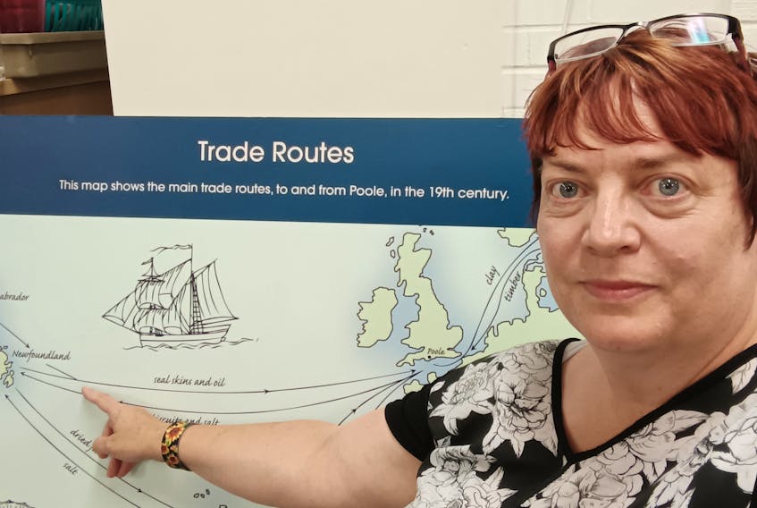 Jenny Fawcett-Grey, project support officer, stands in front of a trade route map developed as part of the ongoing programs in Poole, England, about the town’s historical connections with Newfoundland and Labrador.  -Contributed photo