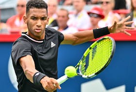 Montreal's Félix Auger-Aliassime hits a return agains Casper Ruud of Norway during quarterfinal action at IGA Stadium on Friday.