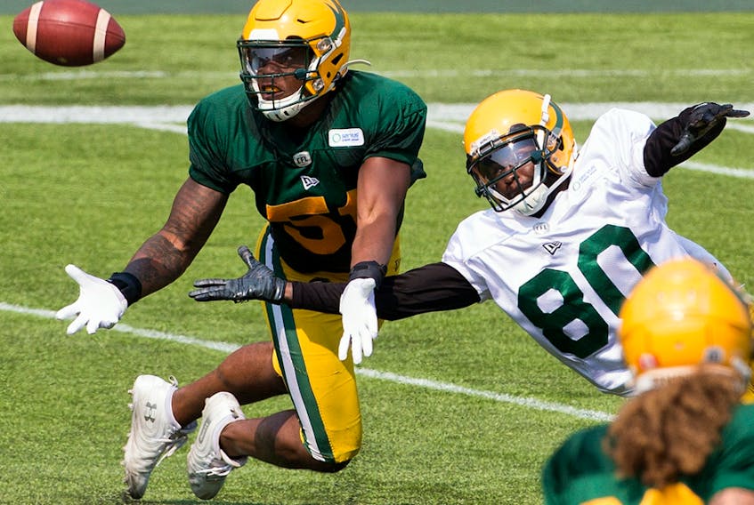 Nyles Morgan (51) and Armanti Edwards (80) battle for the ball during Edmonton Elks training camp at Commonwealth Stadium on July 27, 2021.