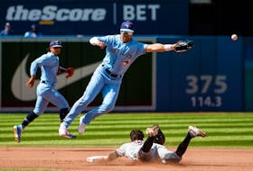 Whit Merrifield of the Blue Jays misses the catch as Tyler Freeman of the Cleveland Guardians steals second base in the fourth inning at Rogers Centre on Sunday, Aug. 14, 2022. 