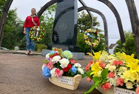 Alicia Rhynold places a wreath in memory of her grandfather, Joseph Parker, the provincial Seaman's Memorial in Canso on Sunday.